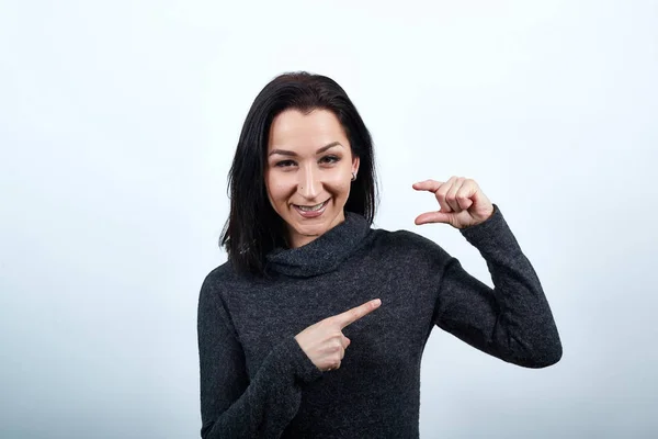 Mulher branca bonita apontando para o espaço entre outros dedos, parece feliz — Fotografia de Stock