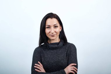 Çekici beyaz kadın ellerini çapraz tutuyor, ciddi görünüyor.