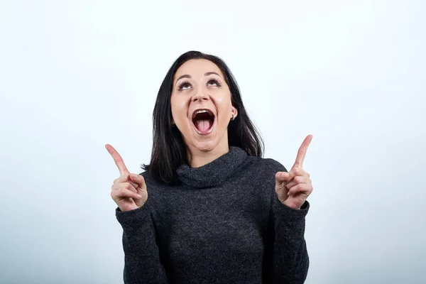 Glada kaukasiska unga kvinna pekar upp, med öppnad mun, ser glad — Stockfoto