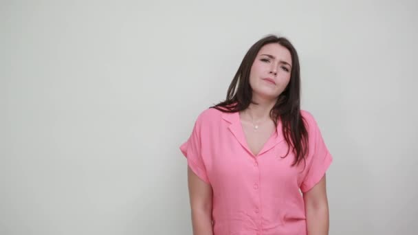 Langweilige junge Frau, die Hand auf den Kopf hält und über etwas nachdenkt — Stockvideo