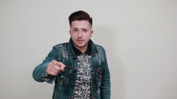 Молодий чоловік спрямовує палець прямо на камеру, виглядаючи серйозно — стокове відео
