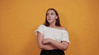 Ciddi bir kadın parmaklarını çenesinde tutuyor, kafası karışık görünüyor, konuyu düşünüyor.