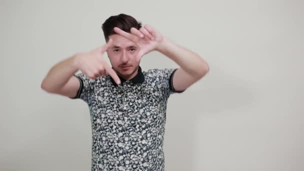 Młody mężczyzna w luźnych ubraniach pozowanie ręce zdjęcie ramki gest. — Wideo stockowe