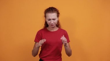 Kırmızı tişörtlü çekici genç bayan ellerini başının üstünde tutuyor, baş ağrısı