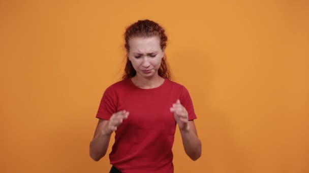 Menina atraente em camisa vermelha mantendo a mão na cabeça, dor de cabeça — Vídeo de Stock