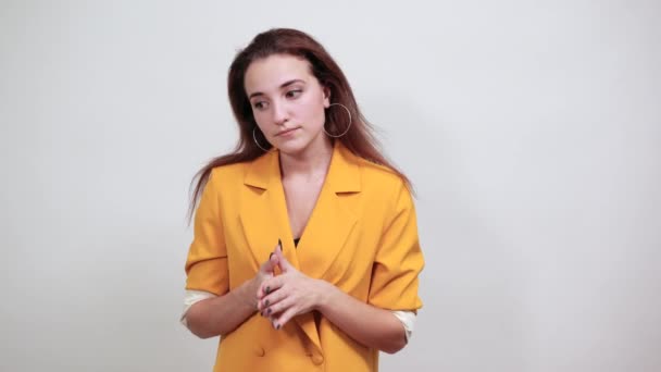 Vrolijke jonge vrouw in geel jasje wrijft haar handen er gelukkig uit — Stockvideo