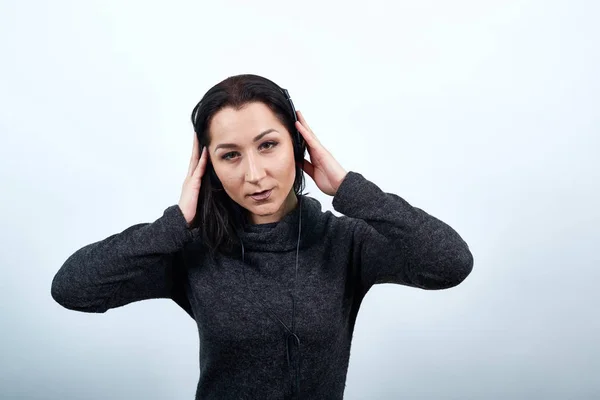 ヘッドフォンで手を取り、音楽を聞く深刻な女性 — ストック写真