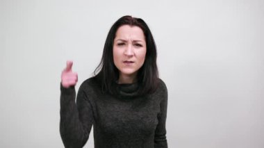 Moda siyah kazaklı mutsuz kadın kameraya bakıyor, kızgın bakıyor.