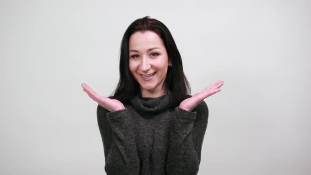 Mujer alegre en la moda suéter negro extiende las manos, sonriendo, mirando feliz — Vídeos de Stock