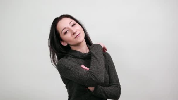 Mooie jonge vrouw houdt handen op het gezicht, doet model gebaar — Stockvideo