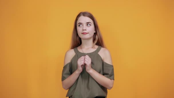 Jolie jeune femme gardant les poings sur la poitrine semble heureux, drôle portant chemise haki — Video