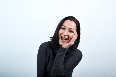 Özenli gülümseyen genç bir kadın el ele tutuşuyor, gülüyor.