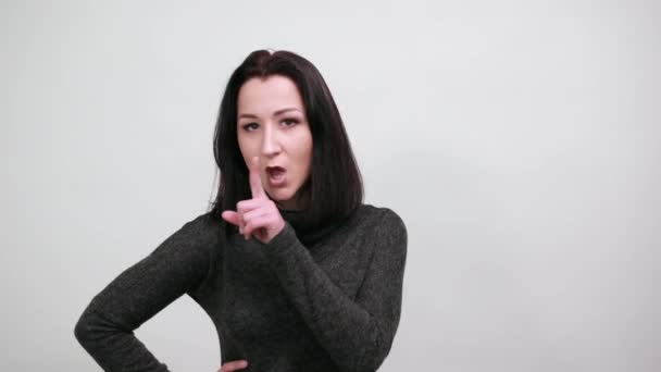 Hermosa mujer joven que señala el espacio entre otros dedos, se ve feliz — Vídeos de Stock