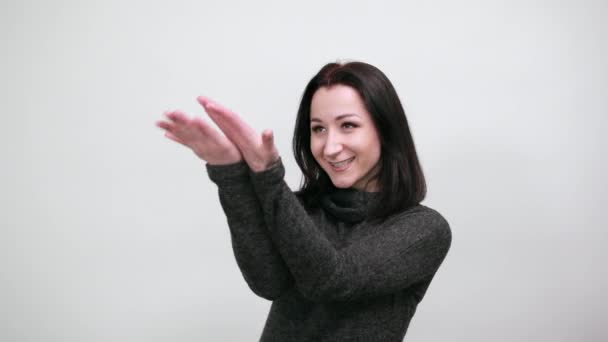 Krásná žena v černém svetru ukazuje ruce do dálky, usmívá se — Stock video