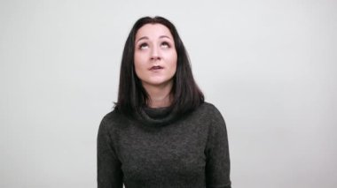 Neşeli, beyaz, genç bir kadın, ağzı açık, mutlu görünüyor.