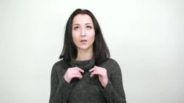 Şok olmuş genç bir kadın elleri açık bir ağızla yüzüne bakıyor.