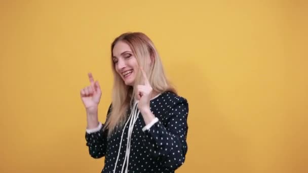 Geschokte blanke jongedame wijst vingers omhoog, ziet er mooi uit — Stockvideo