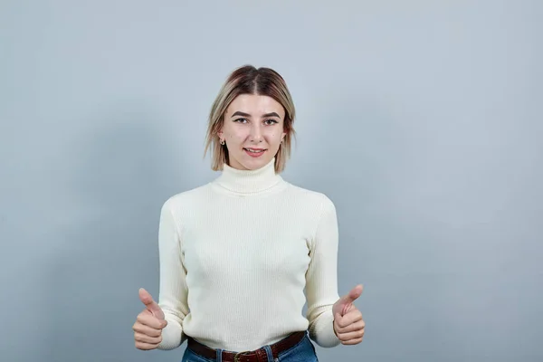 Attraktiv kvinna hålla thunbs upp, ler för att presentera en produkt — Stockfoto