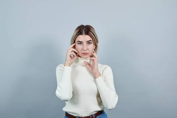 Giovane donna che tiene la mano sul viso, modello gesto isolato sfondo bianco — Foto Stock