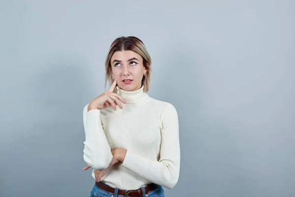 Giovane bella donna attraente guardando in alto, gli occhi aperti con la mano sulla guancia — Foto Stock