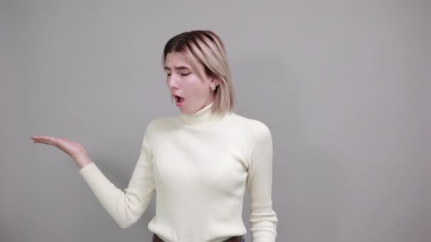 Attraktiv dam skriker och tillkännager något, håller handen åt sidan, skvallrar — Stockvideo