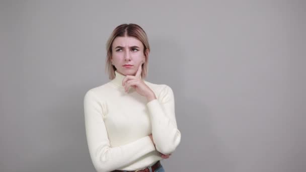 Jonge vrouw kijkt opzij, opent ogen met de hand op kin, denk na over kwestie — Stockvideo