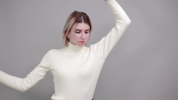 Attraktiv ung stående isolerad över grå bakgrund, stretching händer — Stockvideo