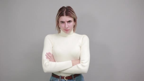 Smiling young woman in casual white sweater holding hands crossed — Stock Video