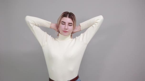 Młoda, zabawna, biała kobieta trzymająca ręce na głowie, patrząca na bok — Wideo stockowe