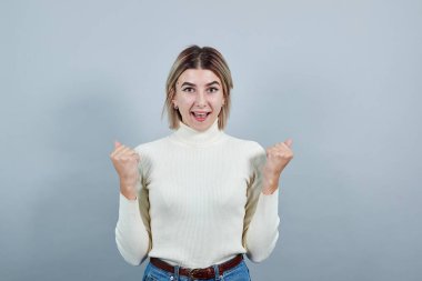 Kolları havada, başarıya gülümseyen, gözleri kapalı bir genç..