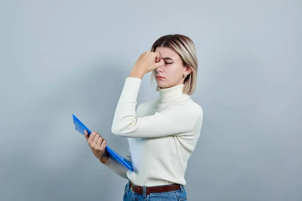 Strikte vrouw houdt map houden hand op neus geïsoleerd op grijze muur — Stockfoto