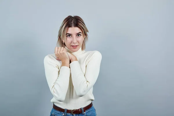 Mujer joven se ve feliz y emocionado mantener los pulgares bajo la barbilla — Foto de Stock