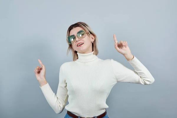 Spännande ung flicka i vita kläder hålla solglasögon, hålla fingrarna upp — Stockfoto