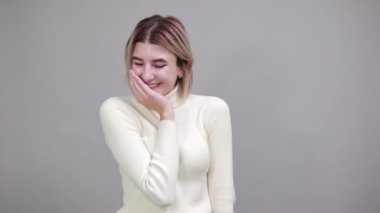 İş yerinde elini yanağından ayırmayan, günlük gömlekli çekici bir kadın..