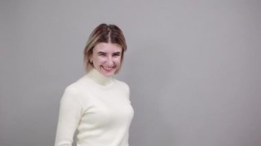 Güzel kadın gülümsüyor ve zafer işareti ve dili gösteriyor.