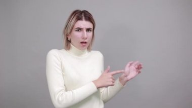 Güzel sarışın bayan parmağını uzağa doğru gösteriyor.