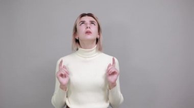 Güzel beyaz kadın şok olmuş görünüyor ve parmağını kaldırıyor.