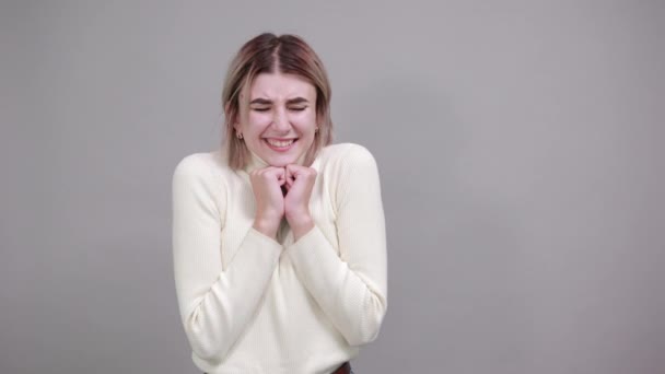 Jong vrij aantrekkelijke vrouw houden hand op kin, glimlachen, kijkt gelukkig — Stockvideo