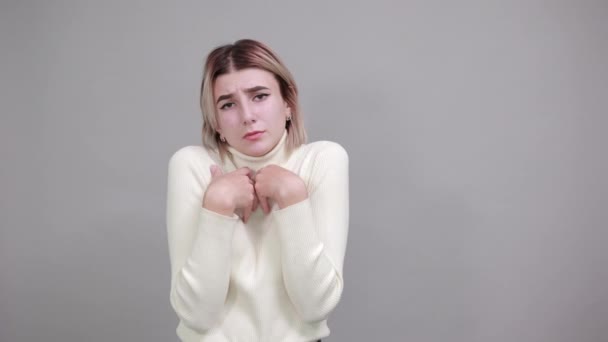 Geschokt vrolijke jonge vrouw in wit shirt, op zoek camera, het verspreiden van handen — Stockvideo