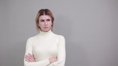 Günlük gömlekli çekici bir kadın çalışma alanına geliyor, ağzını kapalı tutuyor.