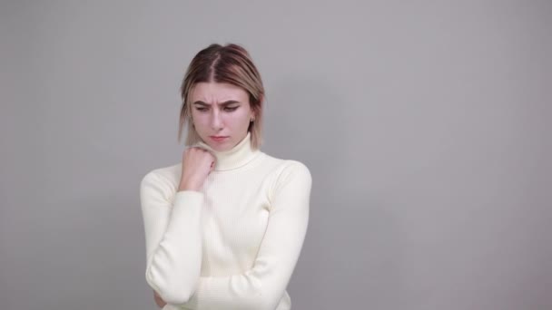 Leende ung kvinna i avslappnade kläder håller händerna på halsen — Stockvideo