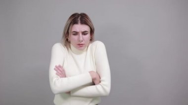 Pastel gömlekli, soğuk mevsim konseptiyle el ele tutuşan katı genç bir kadın..