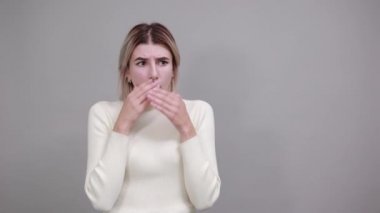 Kadın bağırıyor, bir şeyler söylüyor, ellerini çenenin altında tutuyor..