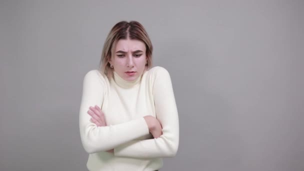 Strikte jonge vrouw in pastel shirt, hand in hand gekruist koude seizoen concept. — Stockvideo