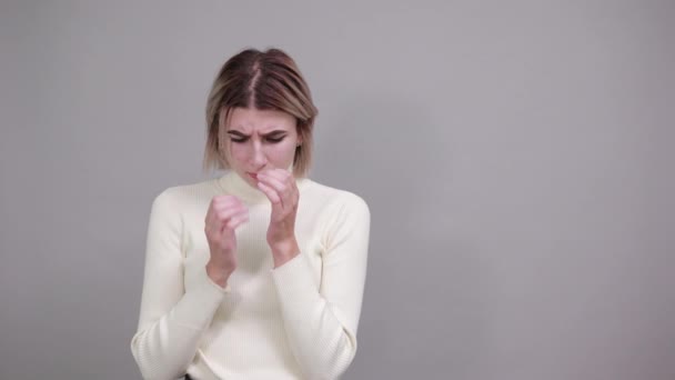 Jeune femme blonde avec expression faciale surprise, couvrant la bouche avec les mains — Video