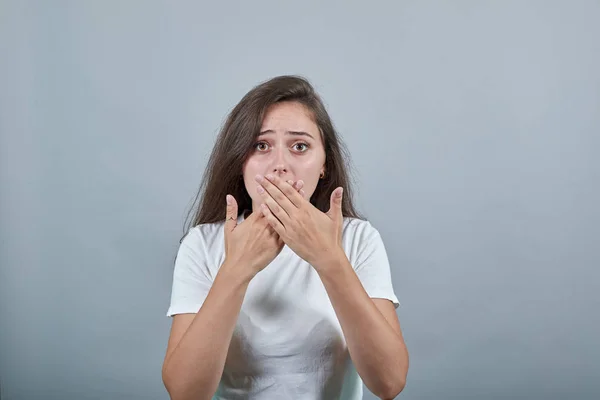 Chica joven esconde su boca con sus manos — Foto de Stock