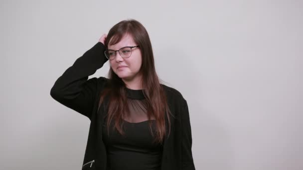 Aantrekkelijke vrouw op zoek gefrustreerd en neemt hand op hand, over grijze muur — Stockvideo
