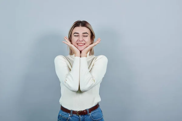 Porträtt av flicka tonåring att hålla händerna nära ansiktet isolerad på grå vägg — Stockfoto
