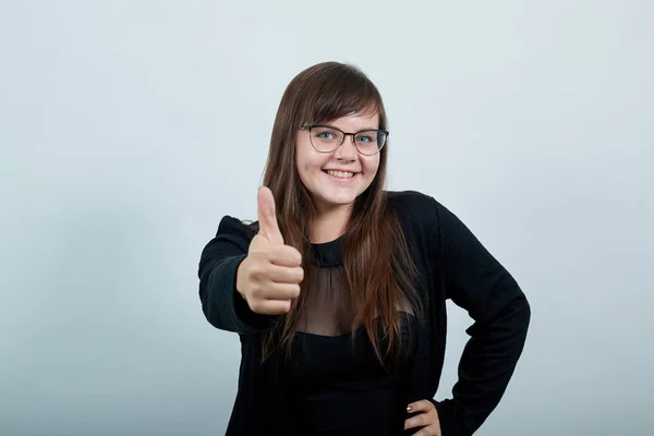 Joven dama caucásica feliz y apuntando con el puño directamente, manteniendo otra mano en la cadera — Foto de Stock