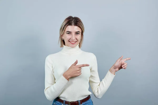 Attraktiv ung kvinna i ledig skjorta visar på arbetsytan, hålla sig undan — Stockfoto